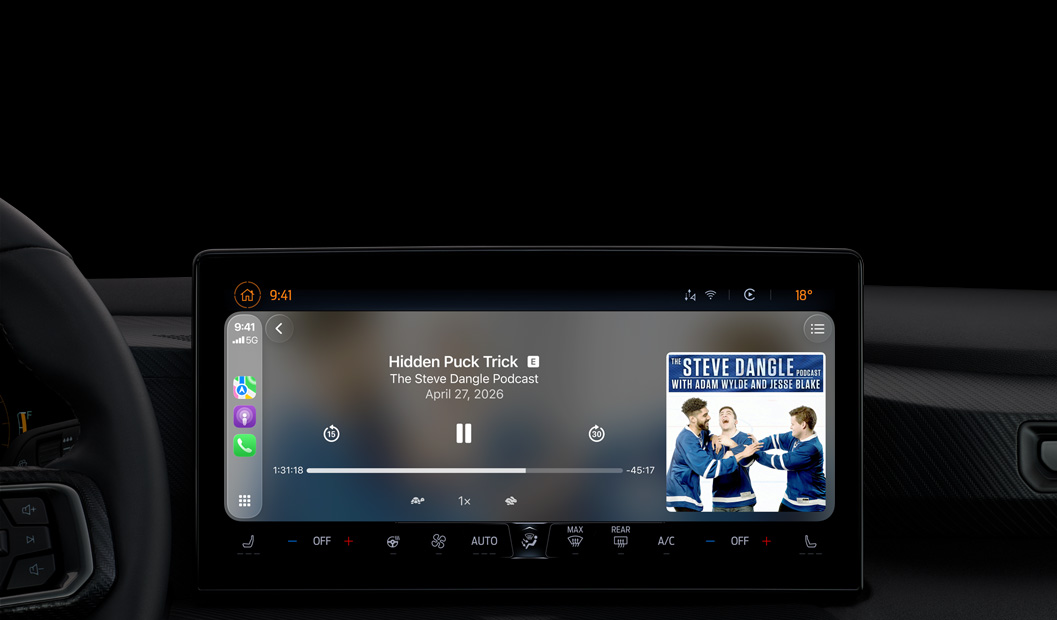 A car interior, center console display shows Apple Podcasts playing via CarPlay, now playing "The Spark of Life" podcast by Radiolab, playback controls include skip back, pause, and skip forward.