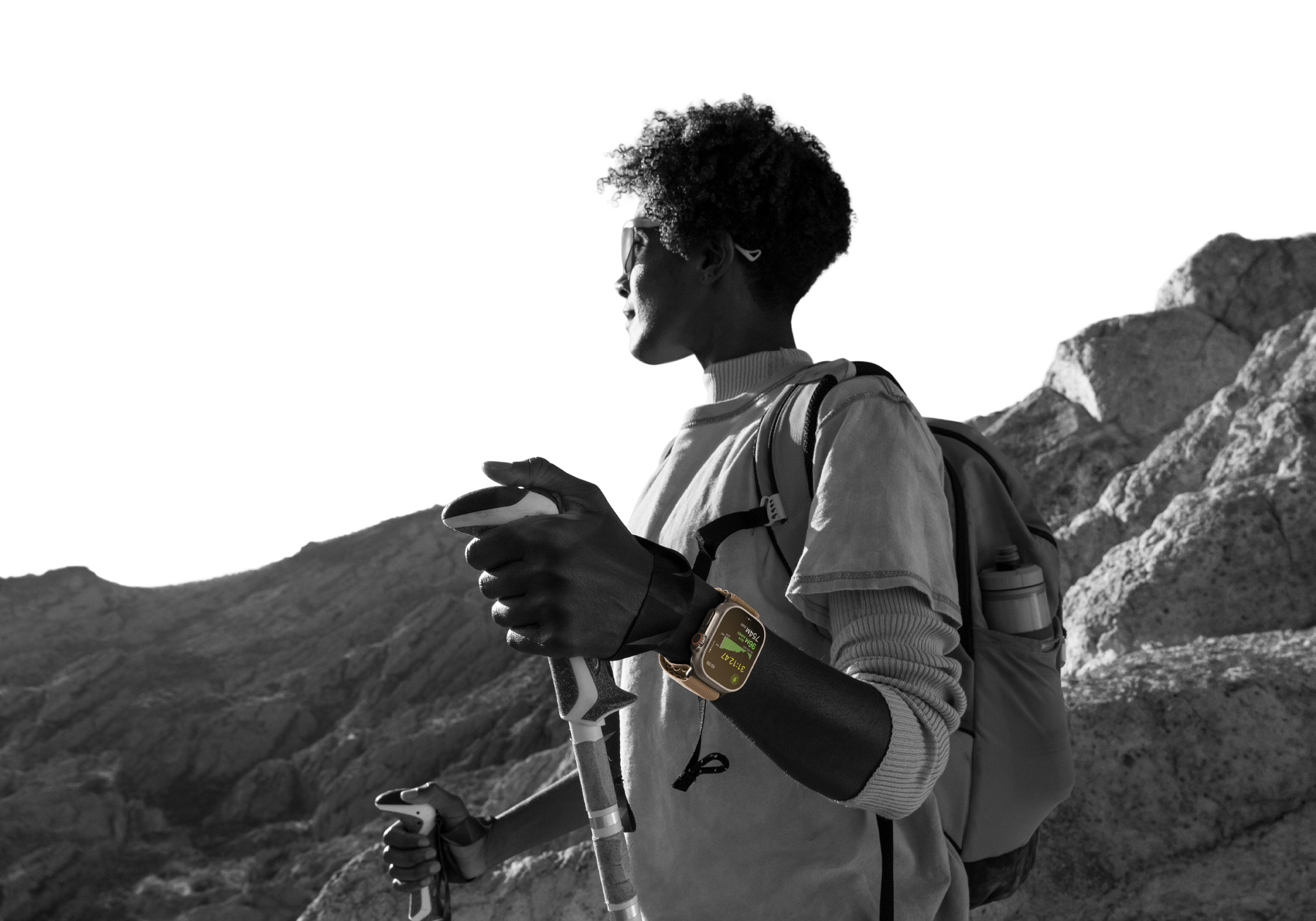 Osoba na pouštní túře s Apple Watch Ultra 4 na zápěstí, na displeji ukazatel nadmořské výšky