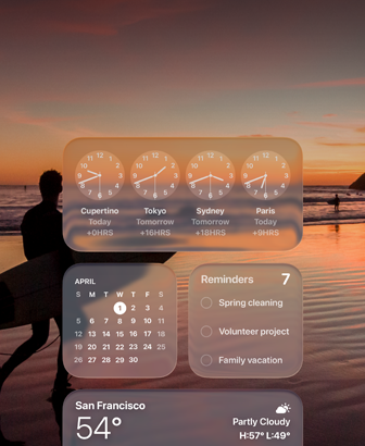 Liquid Glass kell, kalender, meeldetuletused ja ilmarakendus macOS Tahoe ekraanil, mille taustal on stseen surfarist, kes jalutab päikseloojangul rannas