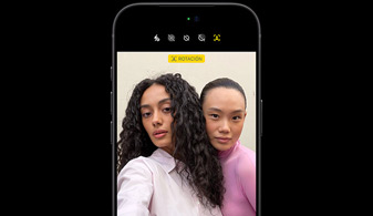 iPhone 18 Pro en negro, parte delantera, la pantalla muestra a dos personas con la prestación de seguimiento de rostros, demostración de la prestación Encuadre Centrado de la cámara frontal