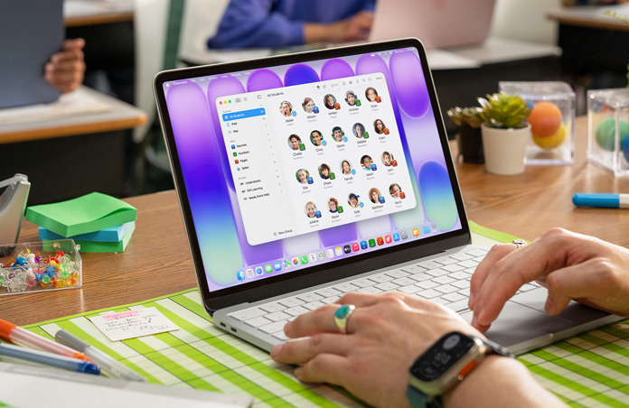 Une enseignante est assise devant un Mac ouvert, avec l’app En classe affichant la liste complète des élèves