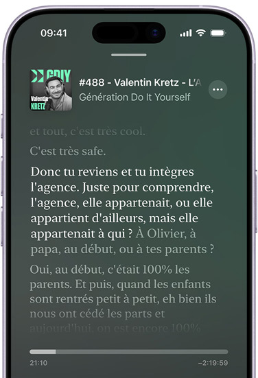 iPhone, face avant, écran affichant une transcription dans Apple Podcasts pour un épisode intitulé Hot Dog du podcast This is Love, animé par Phoebe Judge, le texte en surbrillance dans la transcription indique : "When I was growing up in Chicago, my family would go out for hot dogs all the time", le reste de la transcription s’affiche en caractères plus sombres.