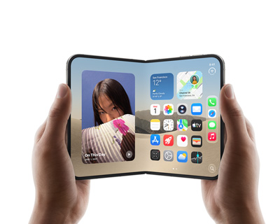 يدان تحملان جهاز iPhone Duo مفتوحاً، الشاشة اليسرى تعرض صورة سيدة، الشاشة اليمنى تعرض الشاشة الرئيسية مع أيقونات لتطبيقات مختلفة تشمل الرسائل والصور والكاميرا وApp Store 