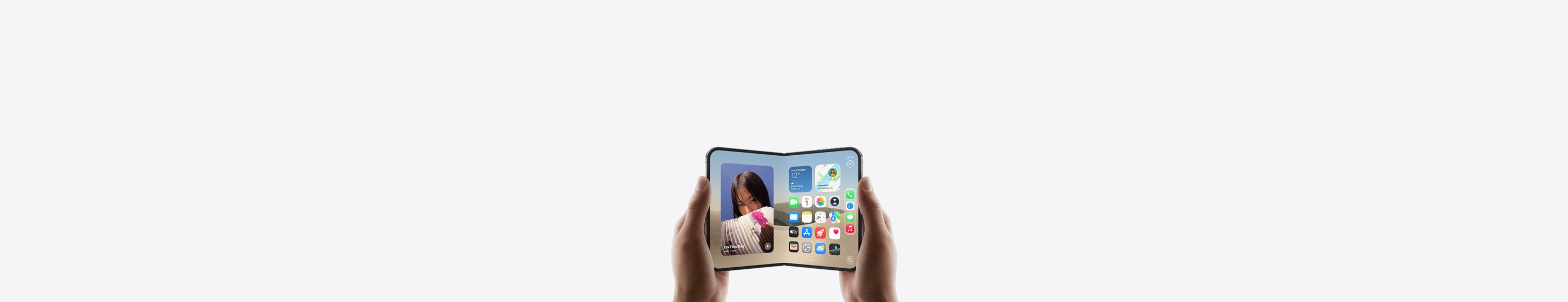 جهاز iPhone Duo، يدان تحملان الجهاز في الوضع الأفقي، مفتوح، الشاشة الداخلية تعرض الشاشة الرئيسية