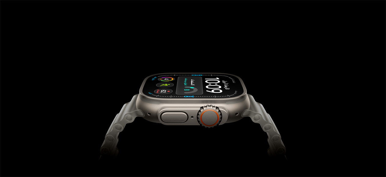 ساعة Apple Watch Ultra 4، إطار من التيتانيوم، لون طبيعي، الجهة الخارجية اليمنى، التاج الرقمي، زر جانبي نافر، واجهة الساعة الرقمية، حزام المحيط بلون رمادي شبه شفاف
