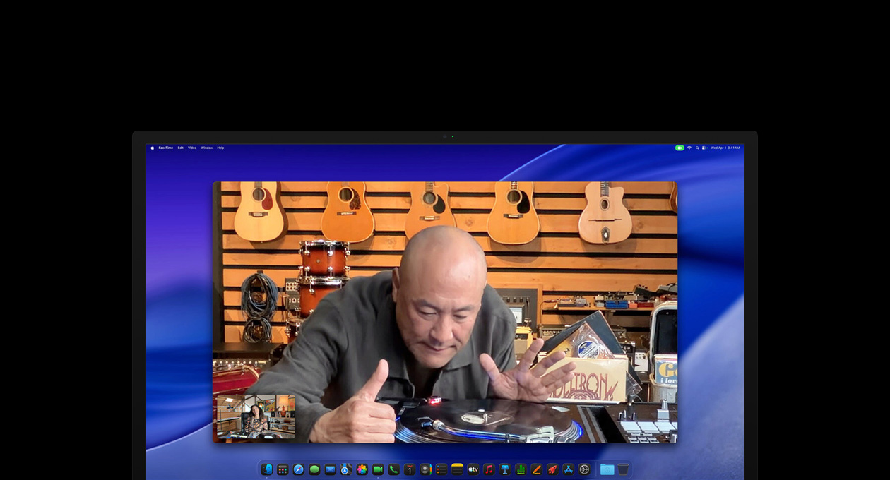 While on a video call, a person at a music store looks closely at a turntable, he remains centered in the frame thanks to the Center Stage camera