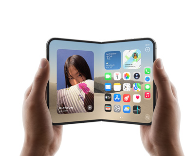 İki el tarafından açık pozisyonda tutulan iPhone Duo, soldaki ekranda bir kadının fotoğrafı, sağdaki ekranda Mesajlar, Fotoğraflar, Kamera ve App Store dahil olmak üzere çeşitli uygulama simgelerinin bulunduğu bir ana ekran gösteriliyor