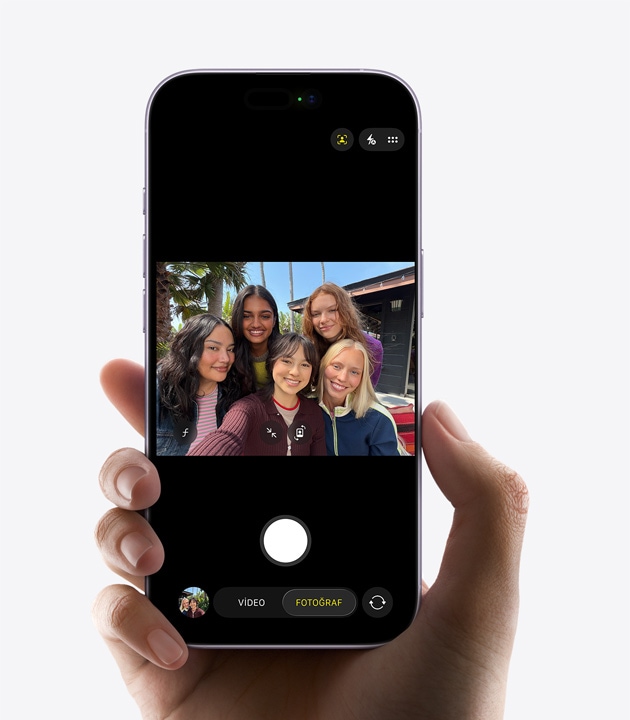 iPhone 17, önden dış görünüm, fotoğraflar için Ana Sahne özelliği kullanılıyor, bir grup insan selfie çekiyor