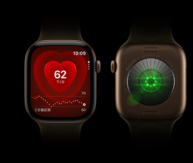 兩隻 Apple Watch Series 12 並排擺放；左邊是 Apple Watch Series 12 的正面圖，螢幕顯示心率監測功能；右邊是 Apple Watch Series 12 的背面圖，發出綠色亮光