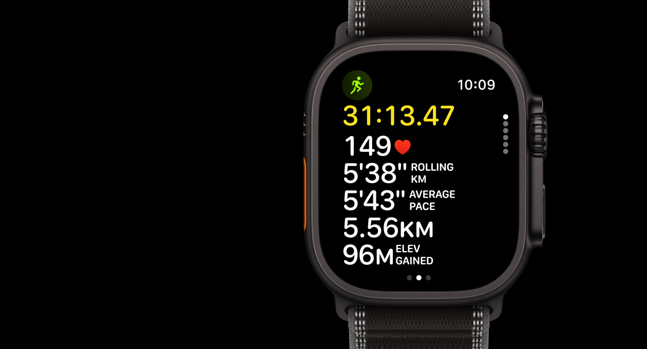 Apple Watch Ultra 3 у титановому корпусі чорного кольору, додаток «Тренування», «Біг надворі», з лівого боку — кнопка дії, з правого боку — коронка Digital Crown і бічна кнопка, браслет Trail чорного/попелястого кольору, анімація