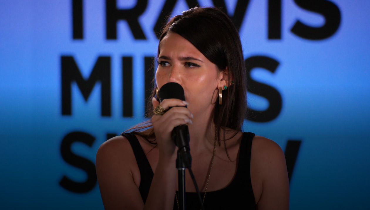 Sienna Spiro singing into a microphone