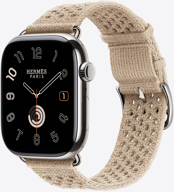 Apple Watch Hermès Series 11, caja de titanio, color plata, acabado pulido, pantalla de borde a borde, esquinas redondeadas, parte lateral derecha, Digital Crown, micrófono, botón lateral, carátula analógica (agujas de hora, minuto y segundo), con la correa Néo Tricot, color Argile (beige), fabricada con hilo de poliamida tejido, orificios de ajuste en el centro, hebilla y componentes color plata