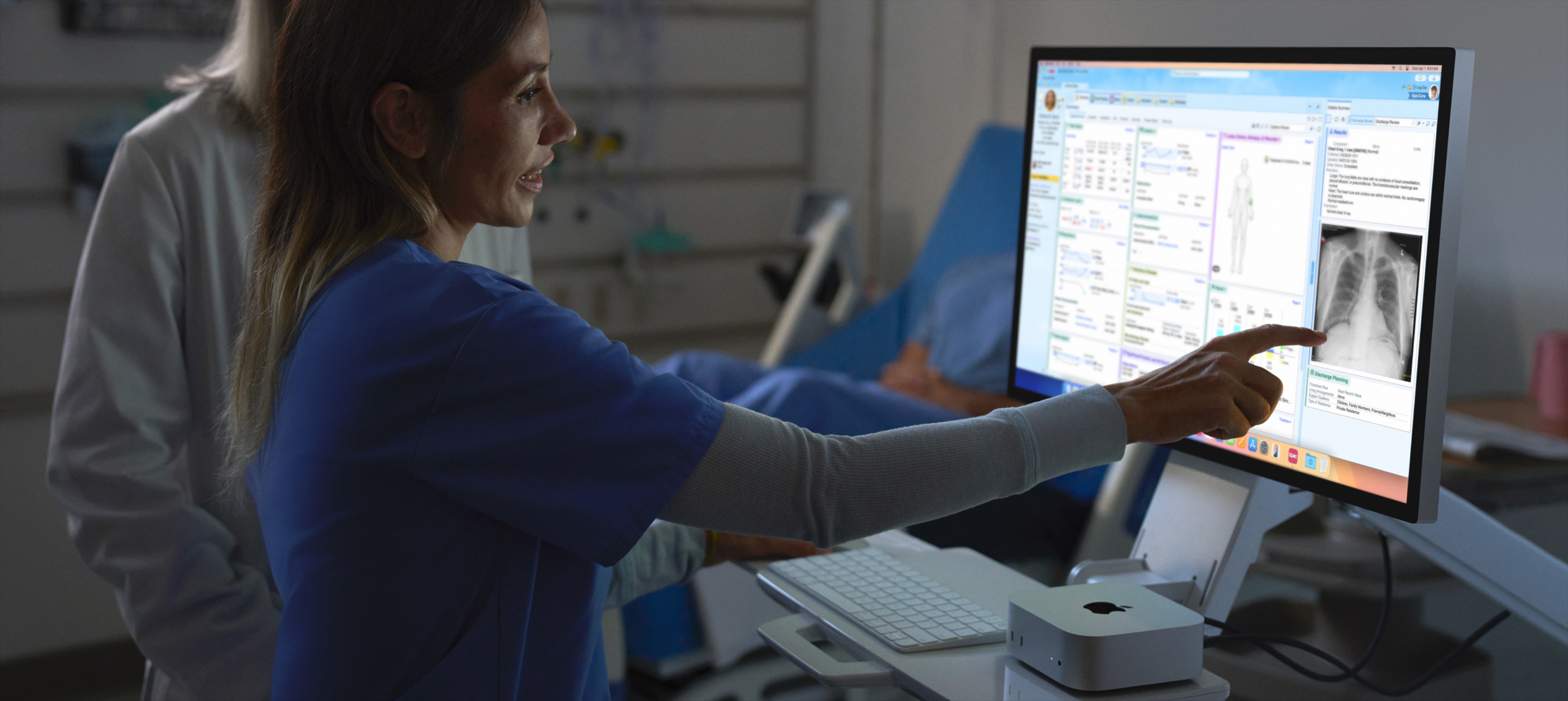 Imagen de una persona de un equipo de enfermería señalando la radiografía de su paciente en un iMac.
