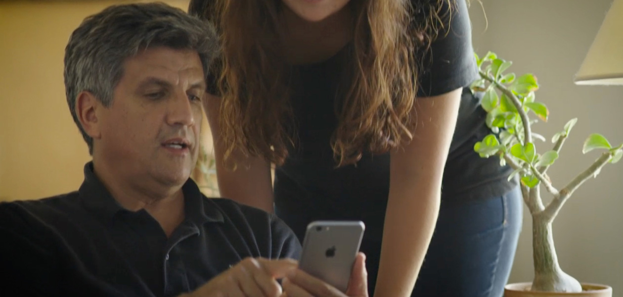 Un hombre le enseña sus datos de salud en el iPhone a la mujer que se encuentra a su lado.
