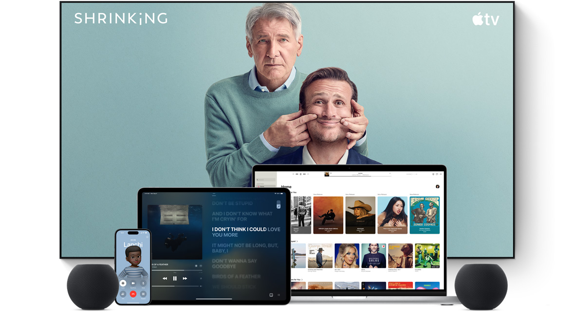 Large flat screen television showing two male characters from the Apple TV series shrinking. A MacBook Pro, an iPad, an iPhone, and a Midnight HomePod mini are arranged in front.