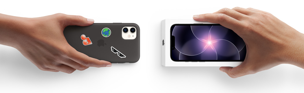 Two hands side-by-side, hand holding iPhone 11 in Silicone Case with stickers on back exterior, trade-in, with hand holding new iPhone 17e box